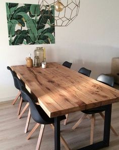 a wooden table with black chairs in a room