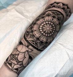 a black and white tattoo with flowers on the arm