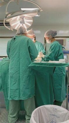 two doctors in scrubs are preparing to perform surgery on a patient's body