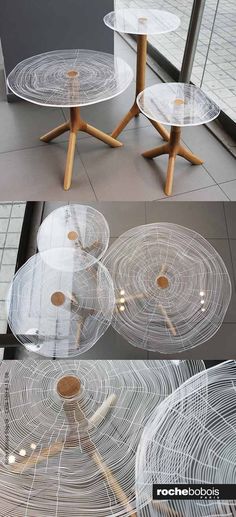 three glass tables with wooden legs and circular designs on them, all in different positions