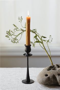 a candle is sitting on a table next to a rock