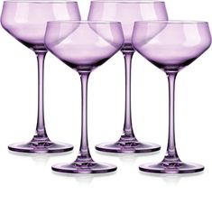 four purple wine glasses sitting next to each other on a white surface with no background