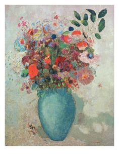 a blue vase filled with lots of colorful flowers