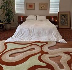 a large bed sitting in the middle of a bedroom next to two pictures on the wall