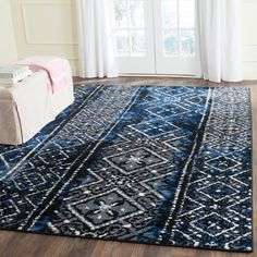 a blue and white area rug in front of a window with curtains on the outside