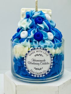 a blue and white cake in a glass container