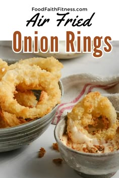 two bowls filled with fried onion rings on top of a white tablecloth next to a red and white towel