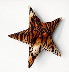 a tiger print star ornament hanging on a wall in front of a white background