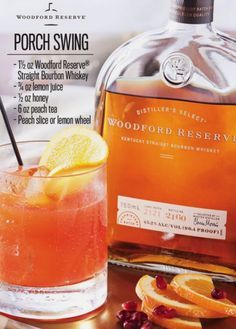 a bottle of woodford reserve sits next to a glass filled with oranges and cranberries