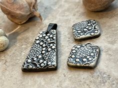 three black and white pendants sitting on top of a table next to some fruit