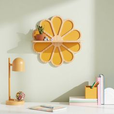 a yellow flower shaped shelf sitting on top of a white desk next to a lamp