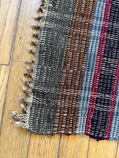 a close up of a rug on a wooden floor with many different colors and patterns