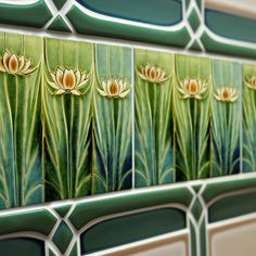 the tile is decorated with water lilies and green leaves on it's sides