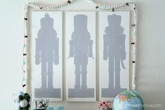 the silhouettes of two soldiers are displayed in front of a wall hanging on a white wall