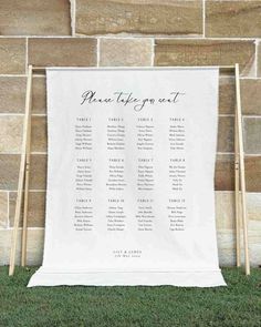 the seating chart for an outdoor ceremony is displayed in front of a stone wall and grass