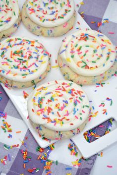 white frosted cookies with sprinkles on a tray