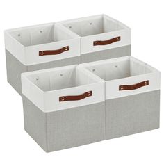 three white storage bins with brown handles