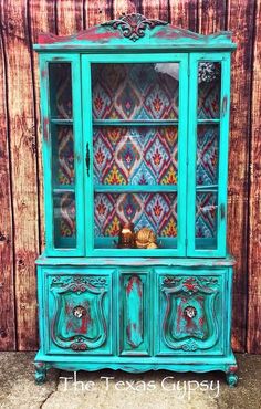 an old china cabinet painted in turquoise and green