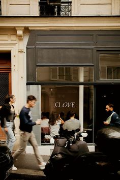 people are walking past a clothing store in the city