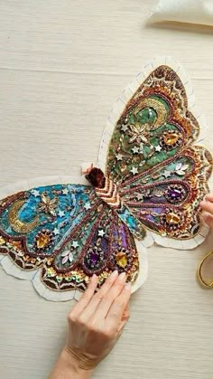 a woman is working on a butterfly decoration