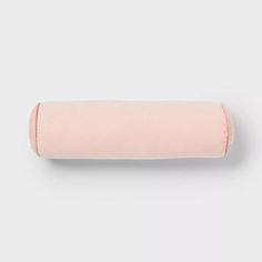 a pink rolled pillow on a white background