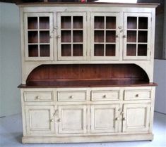 an old white china cabinet with glass doors