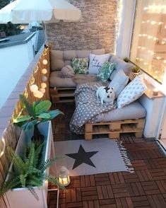 a small balcony with some lights on the side and a white dog sitting on it