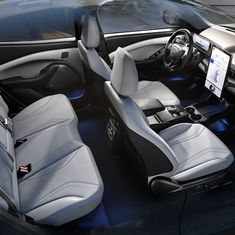 the interior of a car with grey leather seats and electronic screen in front of it