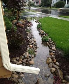 a stream running through a yard next to a house