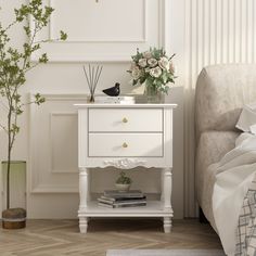 a white bedside table with flowers on top