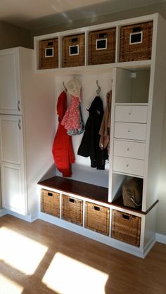 an image of a room with some clothes hanging on the wall and baskets in front of it