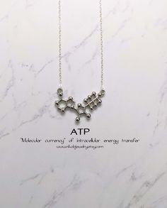 a necklace with the word atp on it, and an image of two letters that are