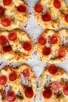 six pepperoni pizzas are arranged on a baking sheet