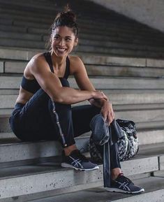 a young woman sitting on the bleachers with her skateboard in front of her