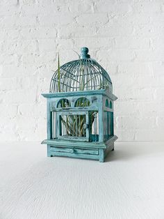 a blue birdcage sitting on top of a table