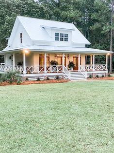 a white house sitting on top of a lush green field