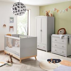 a baby's room with a crib, dressers and other furniture in it