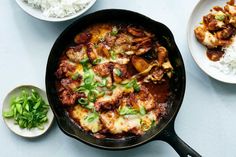 a skillet filled with meat and vegetables next to rice