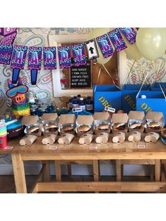 a table topped with lots of food and balloons