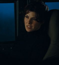 a woman sitting in the back seat of a car at night