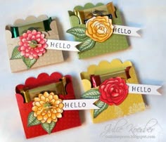 four small boxes with flowers and name tags on them