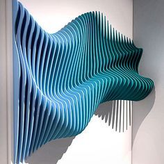 a blue sculpture is hanging on the wall