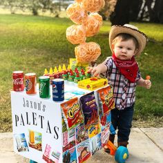 a little boy that is standing in front of a table with some food on it