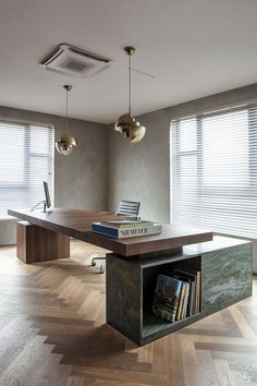 a table with some books on it in the middle of a room next to two windows