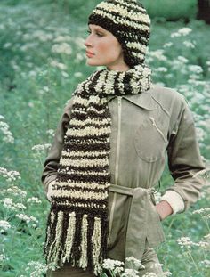 a woman wearing a knitted hat and scarf in a field with wildflowers