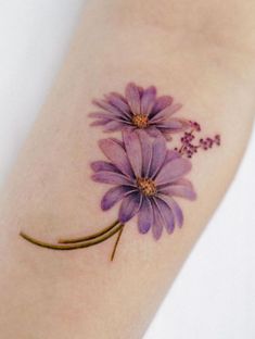 a purple flower tattoo on the left arm