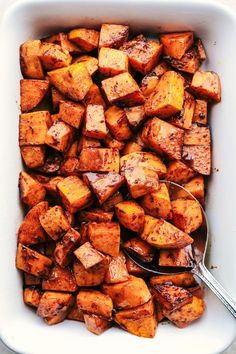 a white dish filled with cooked sweet potatoes