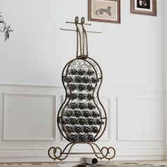 an iron rack with wine glasses on it in the corner of a room next to pictures