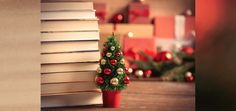 a small christmas tree sitting next to a stack of books