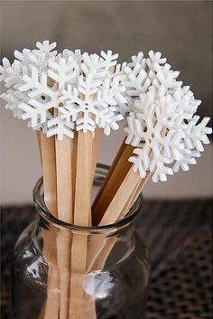 snowflakes in a glass jar with wooden sticks